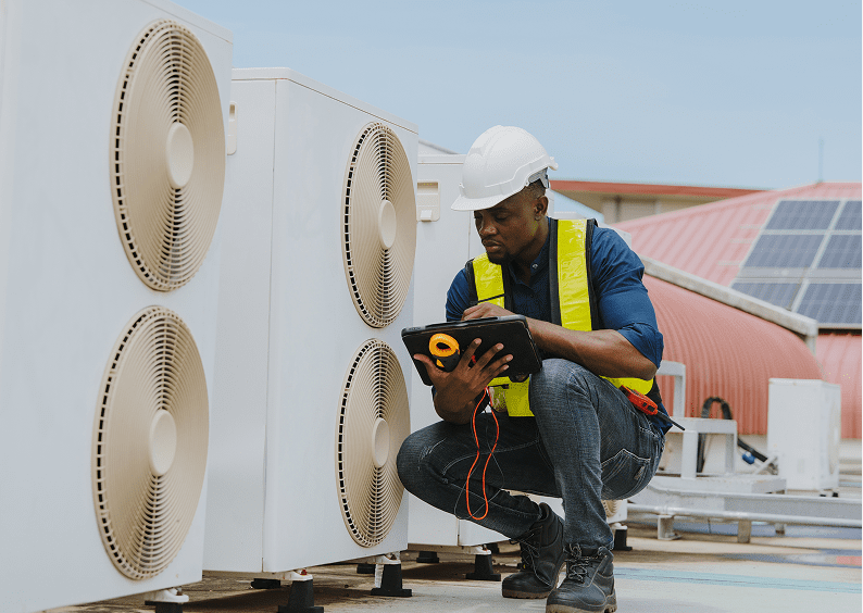 Technician inspecting HVAC unit outdoors