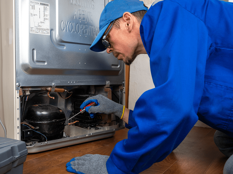 Man in blue uniform fixing appliance.