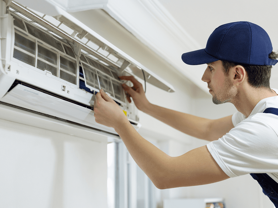 Technician inspecting air conditioning unit